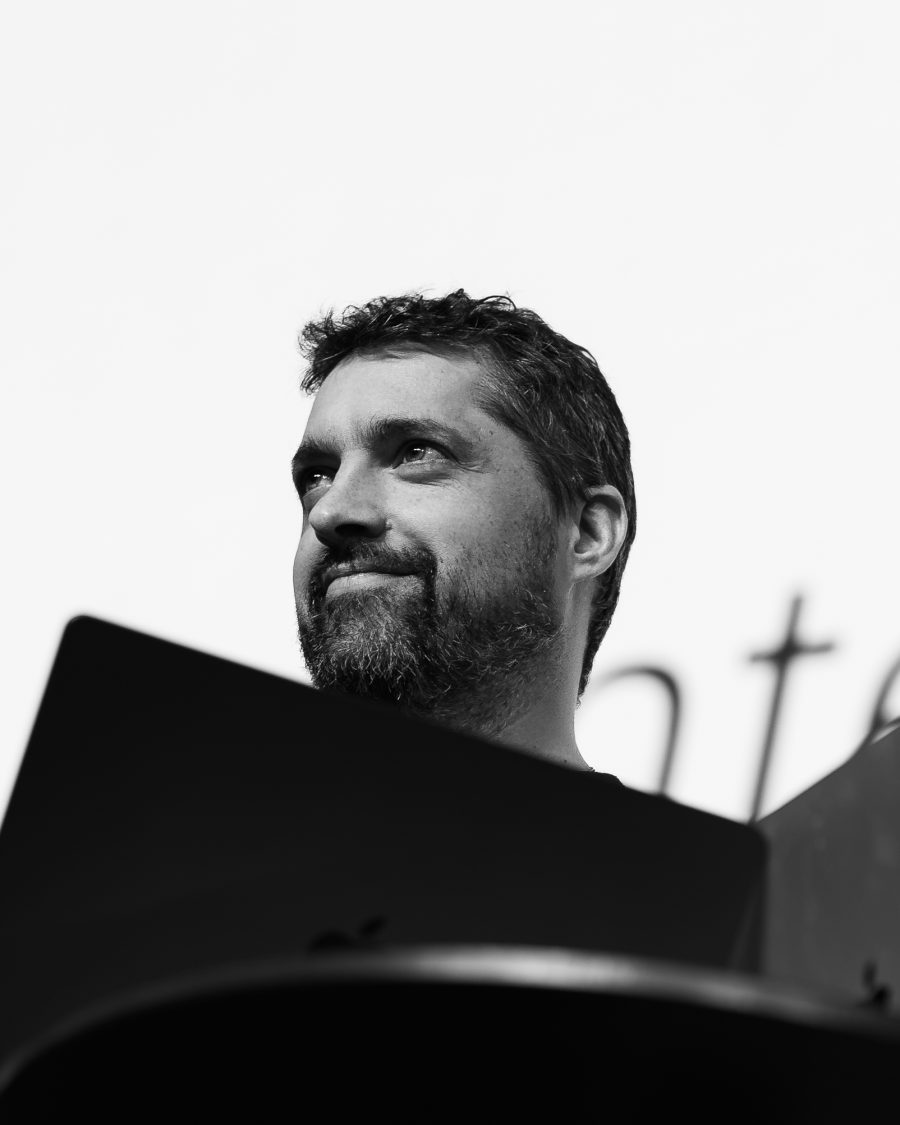 Black and white portrait of Javi at a lectern, looking up